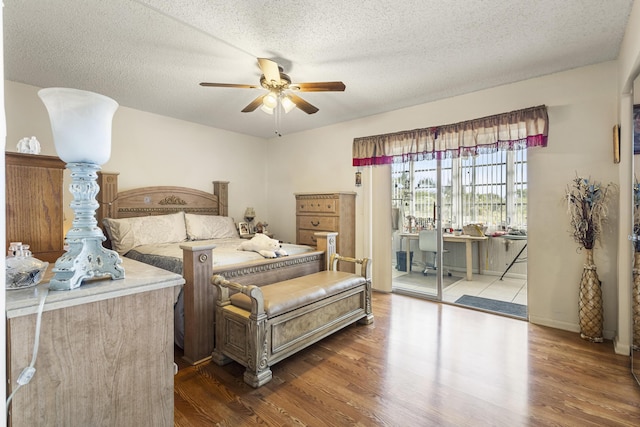 bedroom with ceiling fan, dark wood-type flooring, access to exterior, and a textured ceiling