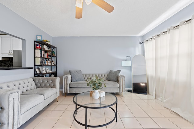 living room featuring light tile patterned floors, a textured ceiling, and ceiling fan