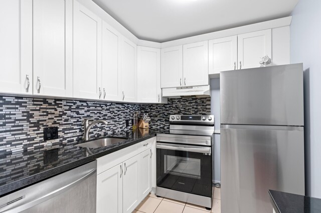 kitchen with white cabinetry, appliances with stainless steel finishes, sink, and light tile patterned floors