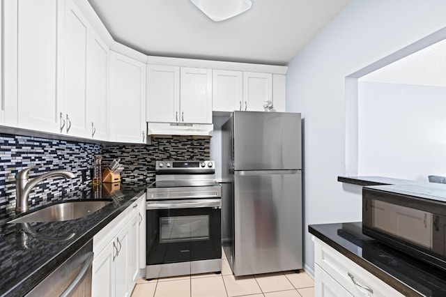 kitchen with appliances with stainless steel finishes, sink, dark stone countertops, and white cabinets