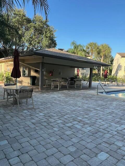 view of patio with a gazebo, a community pool, and a fireplace