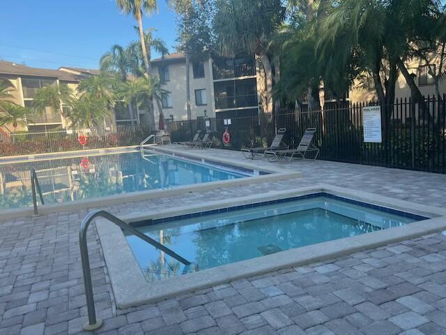 view of pool featuring a community hot tub and a patio area