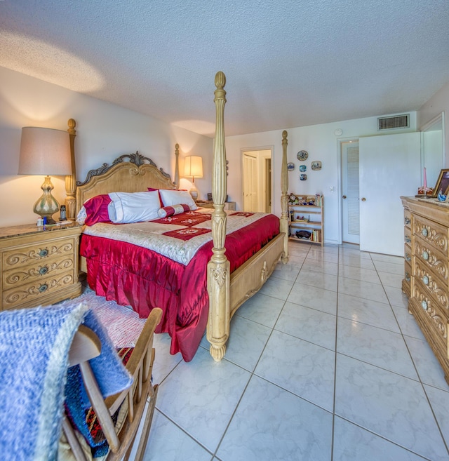 tiled bedroom featuring a textured ceiling