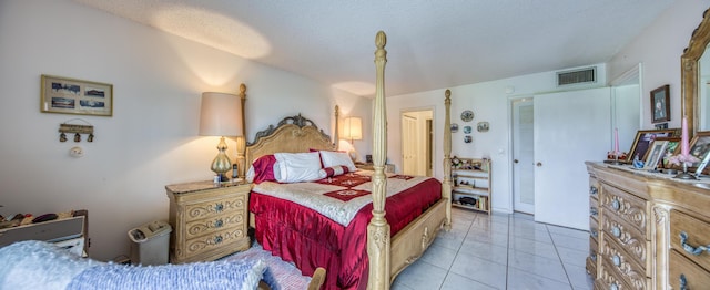 tiled bedroom featuring a textured ceiling