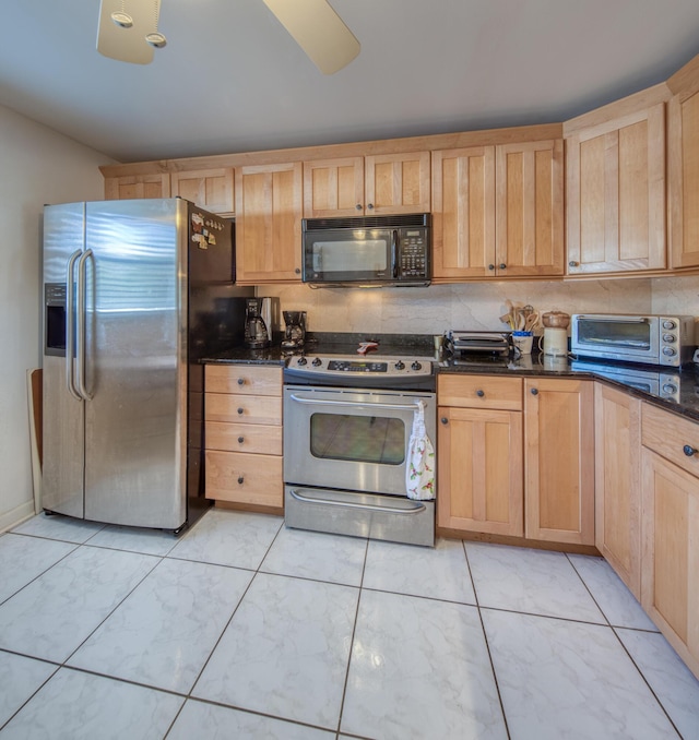 kitchen featuring tasteful backsplash, light brown cabinets, dark stone counters, and appliances with stainless steel finishes