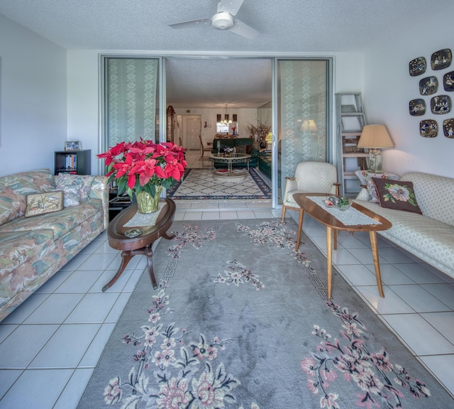 living room with light tile patterned flooring, ceiling fan, and a textured ceiling