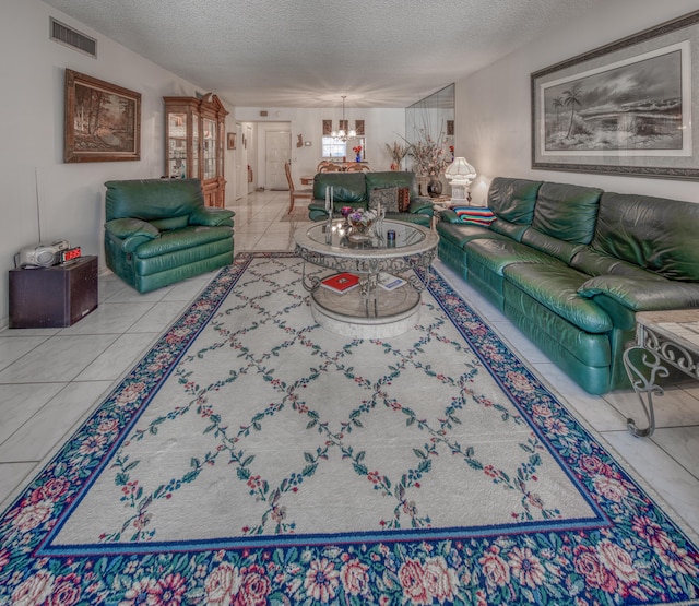 tiled living room featuring an inviting chandelier and a textured ceiling