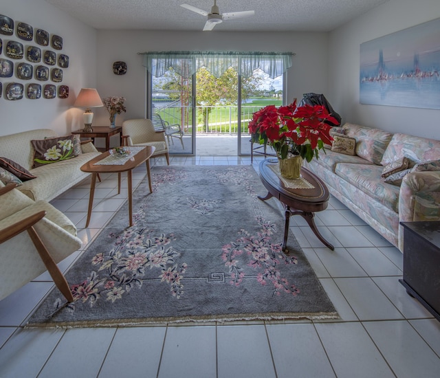 living room featuring ceiling fan, tile patterned floors, and a textured ceiling