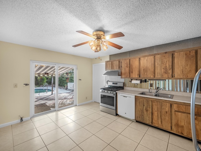 kitchen with dishwasher, sink, light tile patterned floors, ceiling fan, and gas range