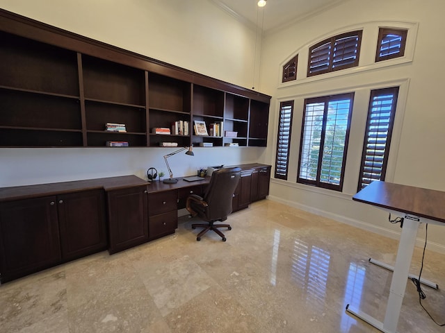 office featuring ornamental molding, built in desk, and a high ceiling