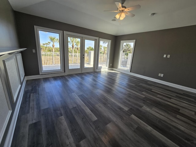 empty room featuring french doors, ceiling fan, lofted ceiling, and dark hardwood / wood-style flooring