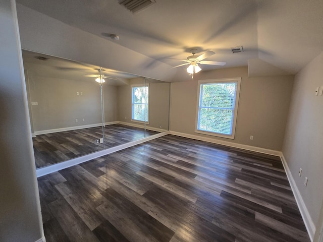 unfurnished bedroom featuring vaulted ceiling, ceiling fan, dark hardwood / wood-style flooring, and a closet