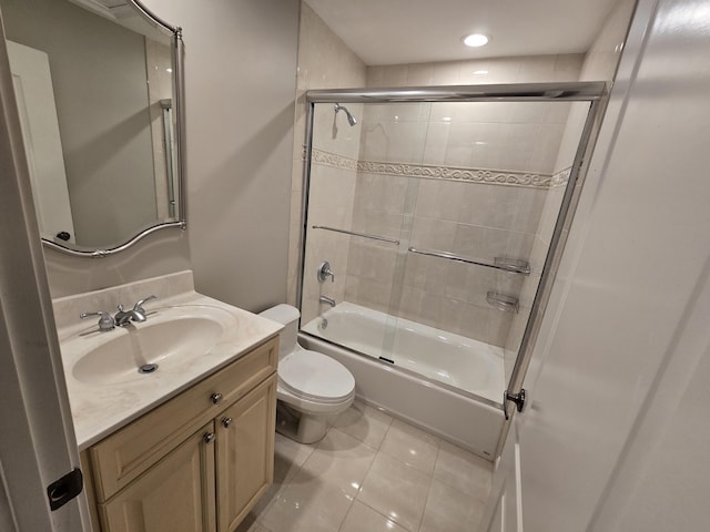 full bathroom with tile patterned flooring, vanity, combined bath / shower with glass door, and toilet