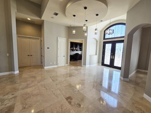 entryway with french doors and a towering ceiling