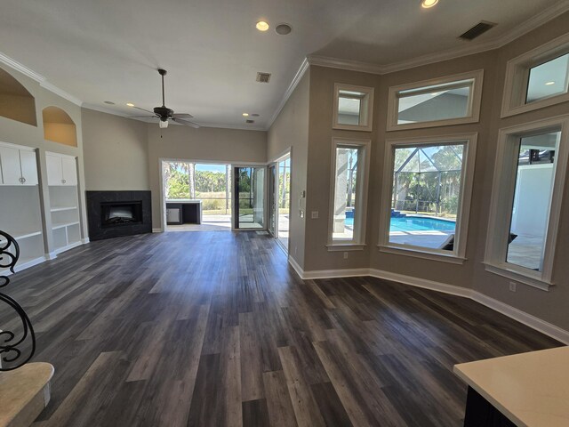 unfurnished living room with dark hardwood / wood-style flooring, crown molding, and ceiling fan