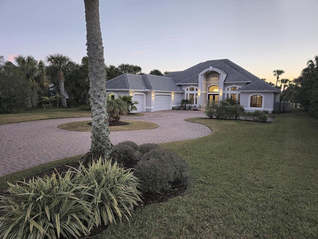 view of front of house featuring a garage and a yard