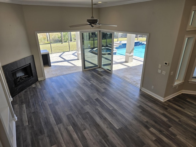 unfurnished living room with crown molding, dark hardwood / wood-style floors, and ceiling fan