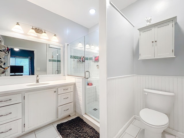 bathroom with tile patterned flooring, walk in shower, vanity, and toilet