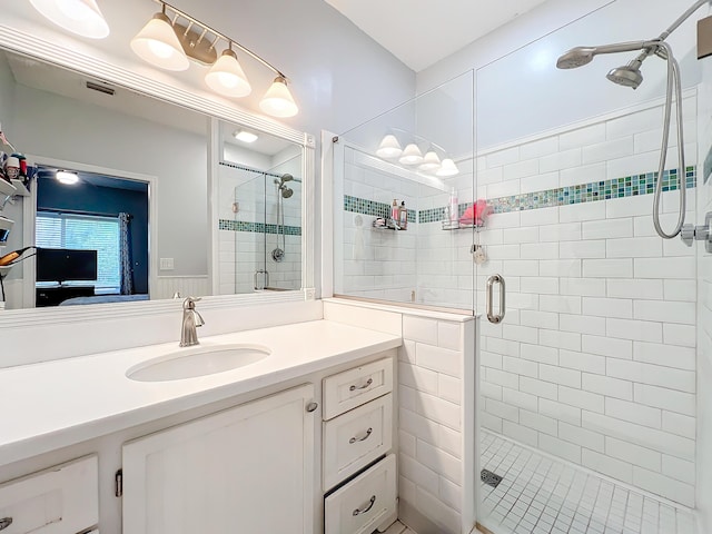 bathroom featuring vanity and a shower with shower door