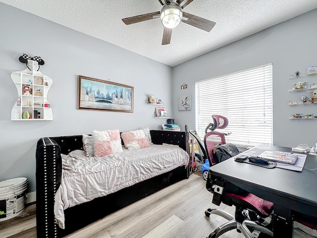 bedroom with ceiling fan, a textured ceiling, and light hardwood / wood-style flooring