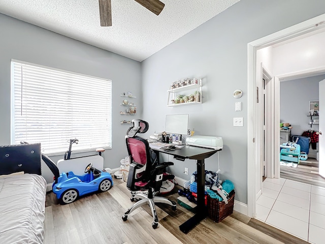 office featuring ceiling fan, light hardwood / wood-style floors, and a textured ceiling