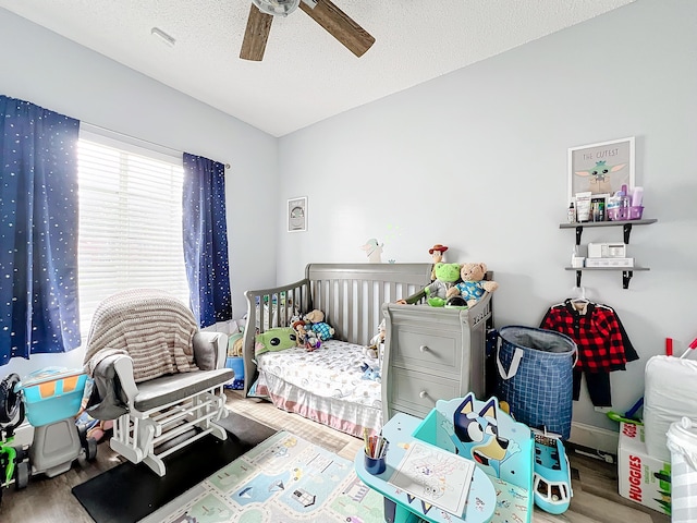 bedroom with wood-type flooring, ceiling fan, and a textured ceiling