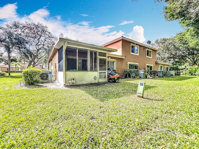 back of house with a yard, a sunroom, and ac unit