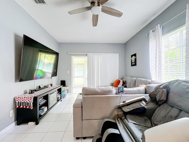 living room featuring light tile patterned floors, a textured ceiling, a healthy amount of sunlight, and ceiling fan