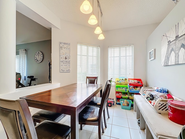 tiled dining space featuring a textured ceiling