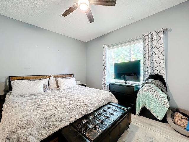 bedroom with ceiling fan and a textured ceiling