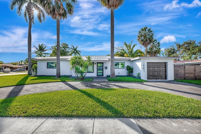 single story home featuring a garage and a front lawn