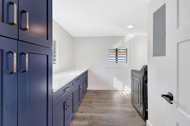 bathroom with electric panel, washer / dryer, and hardwood / wood-style floors