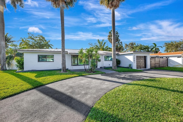 ranch-style house with a garage and a front lawn