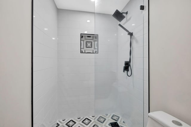 bathroom featuring a tile shower and toilet