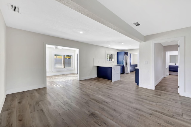 unfurnished living room featuring sink and light wood-type flooring