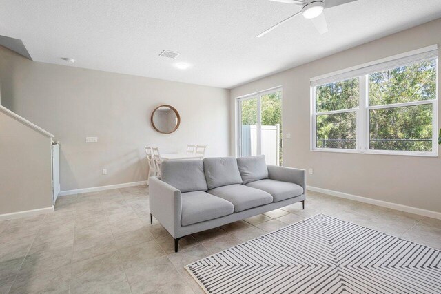 tiled living room with ceiling fan