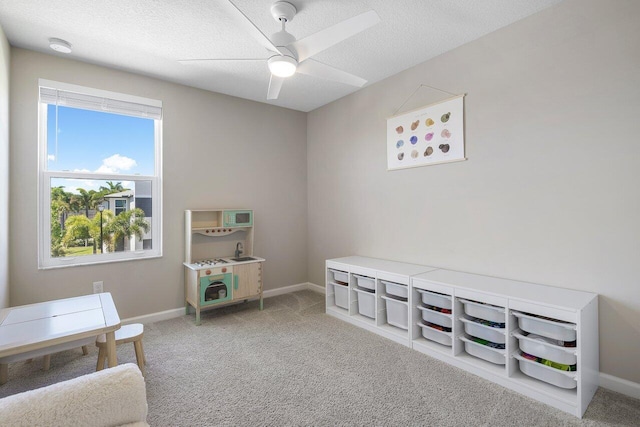 sitting room featuring a textured ceiling, ceiling fan, and carpet