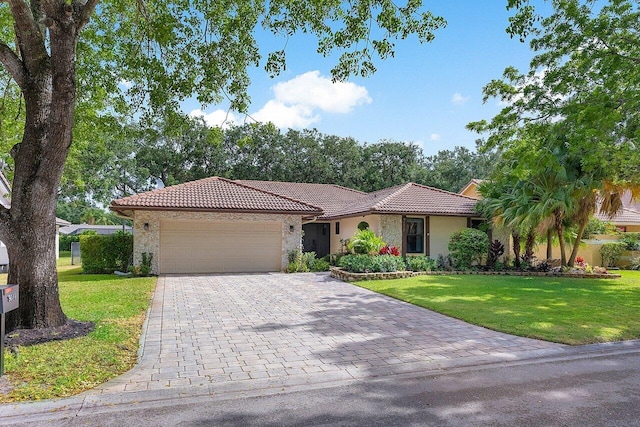 view of front facade with a front lawn, a tile roof, and an attached garage