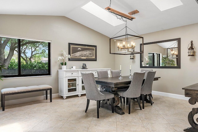 dining space featuring lofted ceiling with skylight, a chandelier, baseboards, and light tile patterned floors