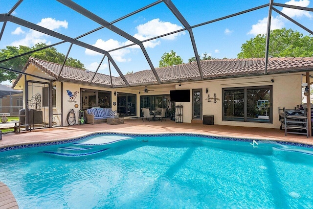 outdoor pool featuring glass enclosure, a patio, and ceiling fan