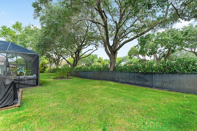 view of yard featuring a lanai and fence