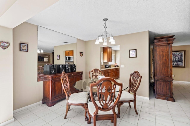 dining area with a chandelier, a textured ceiling, and light tile patterned floors