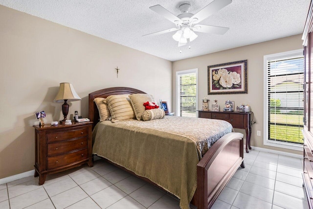 tiled bedroom with ceiling fan and a textured ceiling