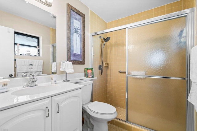 bathroom featuring vanity, toilet, and a shower with door