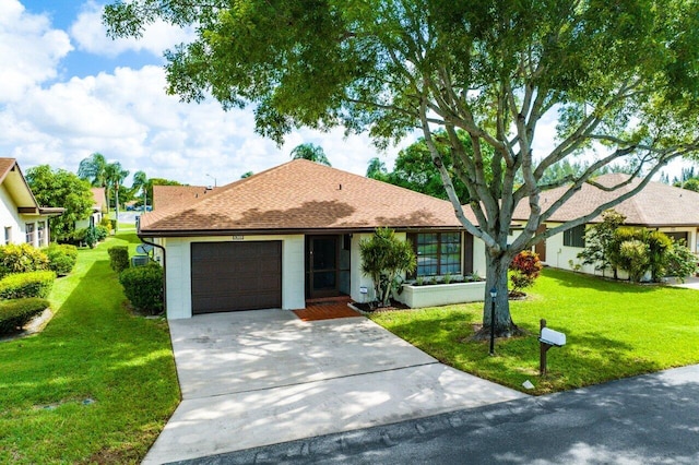 ranch-style house featuring a garage and a front lawn