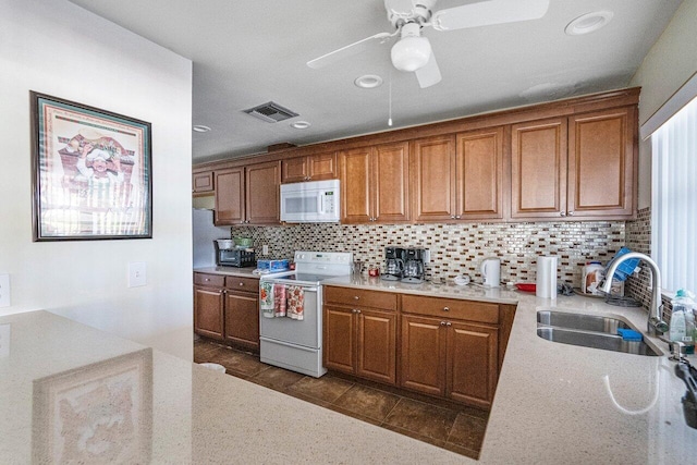 kitchen featuring tasteful backsplash, ceiling fan, sink, and white appliances