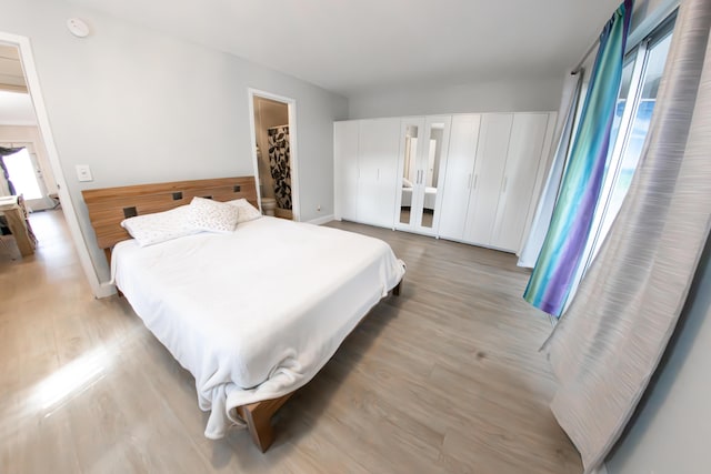 bedroom featuring a spacious closet and light hardwood / wood-style floors