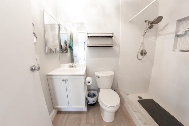 bathroom with walk in shower, vanity, toilet, and hardwood / wood-style floors