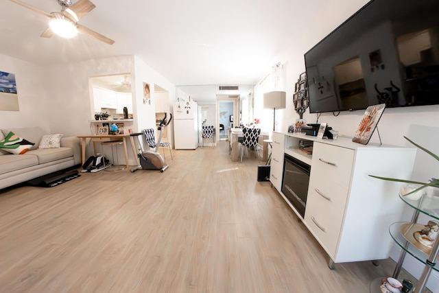 kitchen featuring ceiling fan, white fridge, white cabinets, and light wood-type flooring