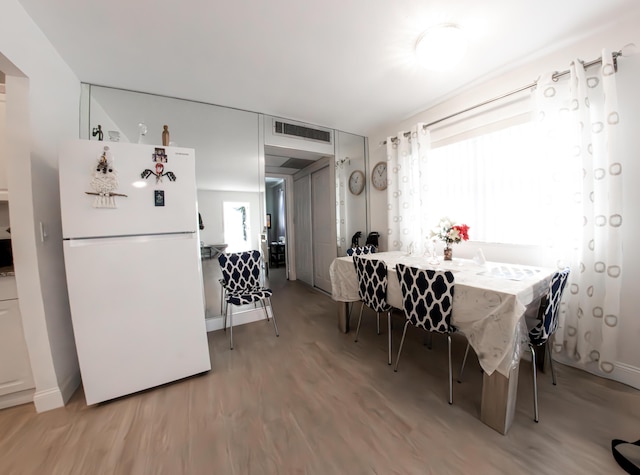 dining area featuring light hardwood / wood-style flooring and a healthy amount of sunlight